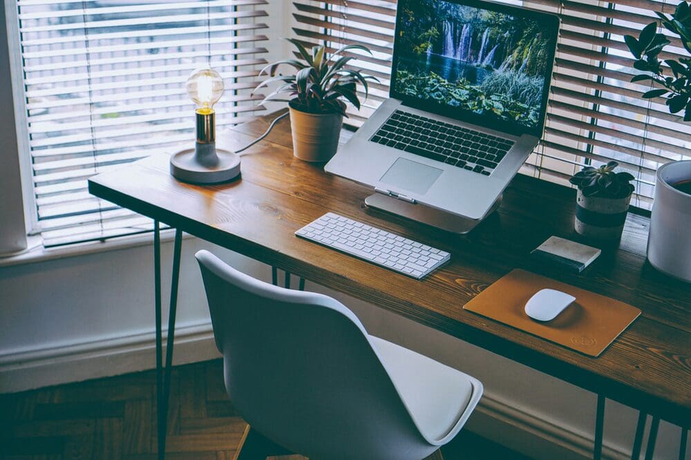 an office space with wooden desk and lamp