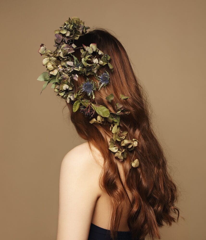 a woman with long natural hair with flowers in